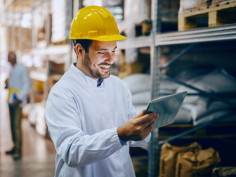 An external occupational safety specialist uses iManSys contentedly on a tablet at the client's site in the warehouse.
