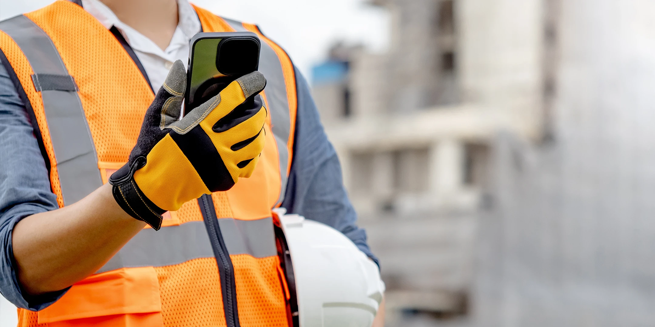 A man in protective gear operates a smartphone