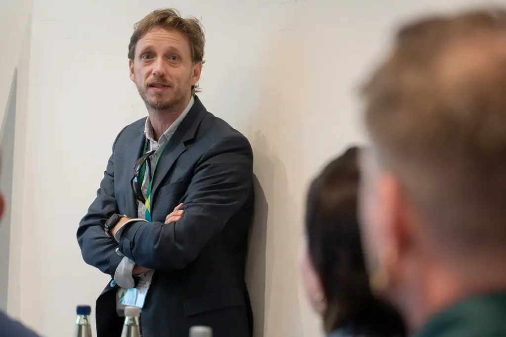 Speaker bei den Compliance Days 2025 lehnt sich an Wand an.
